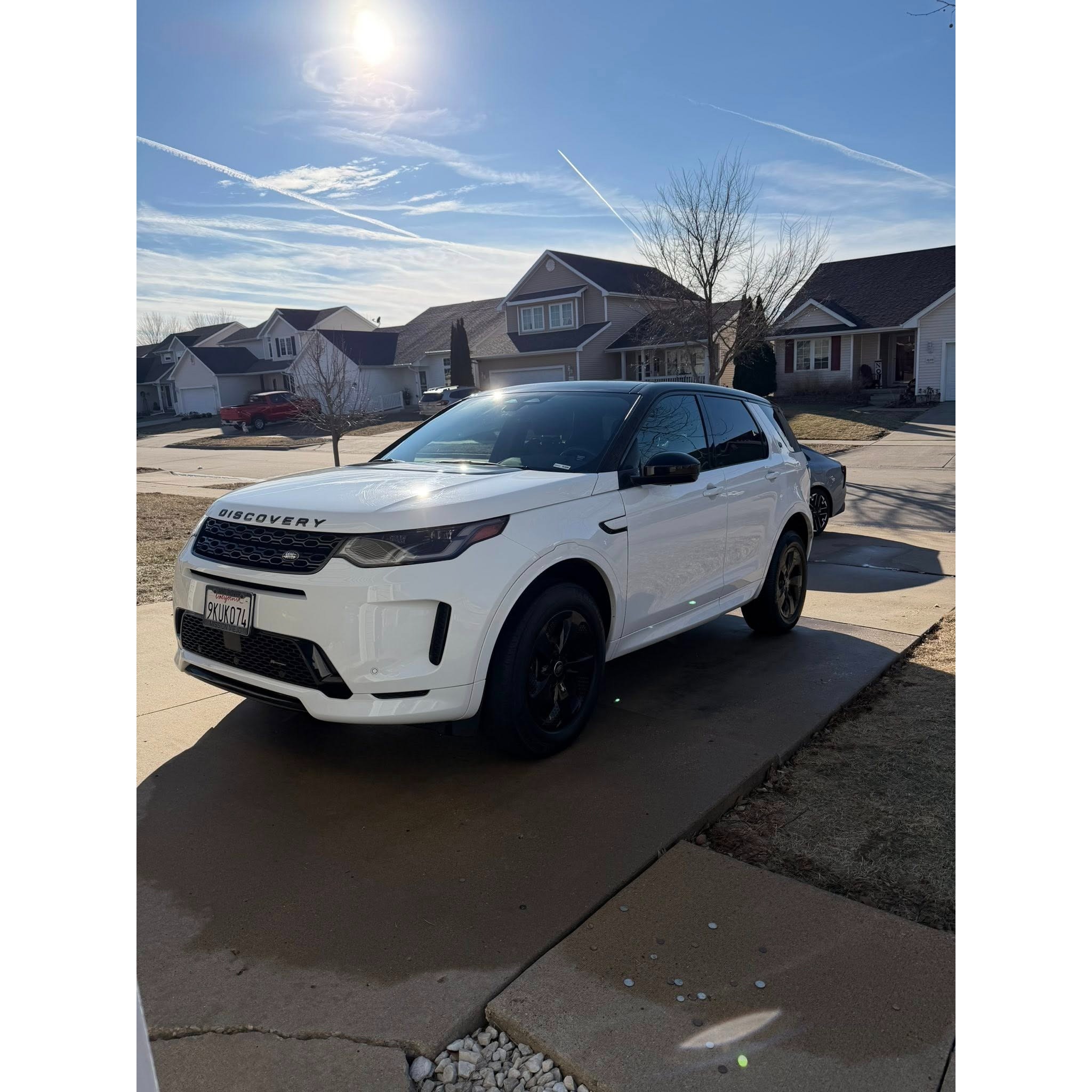 White Land Rover Discovery parked in a residential driveway after mobile detailing, showcasing a clean exterior finish, glossy paint, and polished presentation.