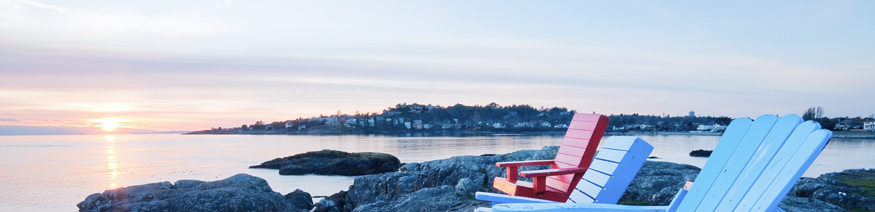 Colourful Muskoka chairs overlooking the water.