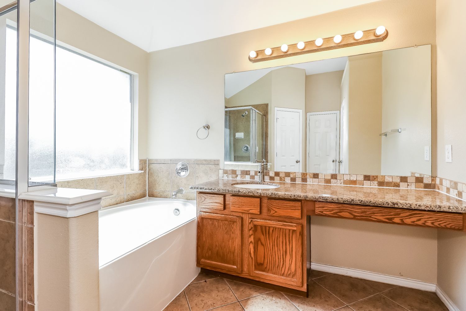 Primary bathroom with shower and tub at Invitation Homes Dallas.