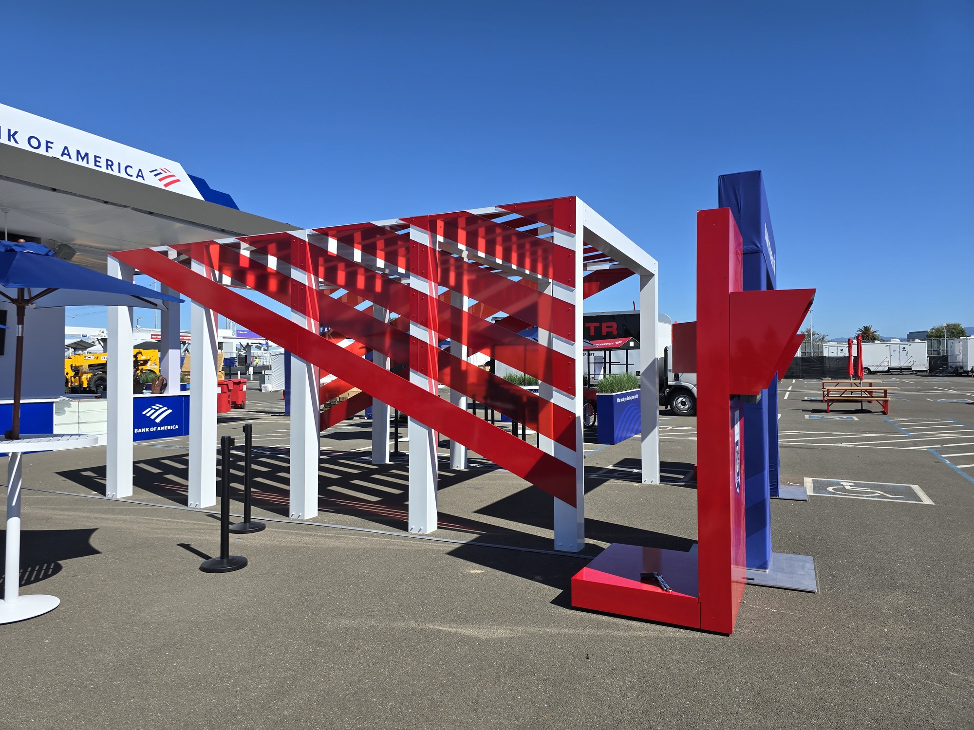 Side view of the custom red, white, and blue exhibit structure with layered graphic panels and an interactive display station.