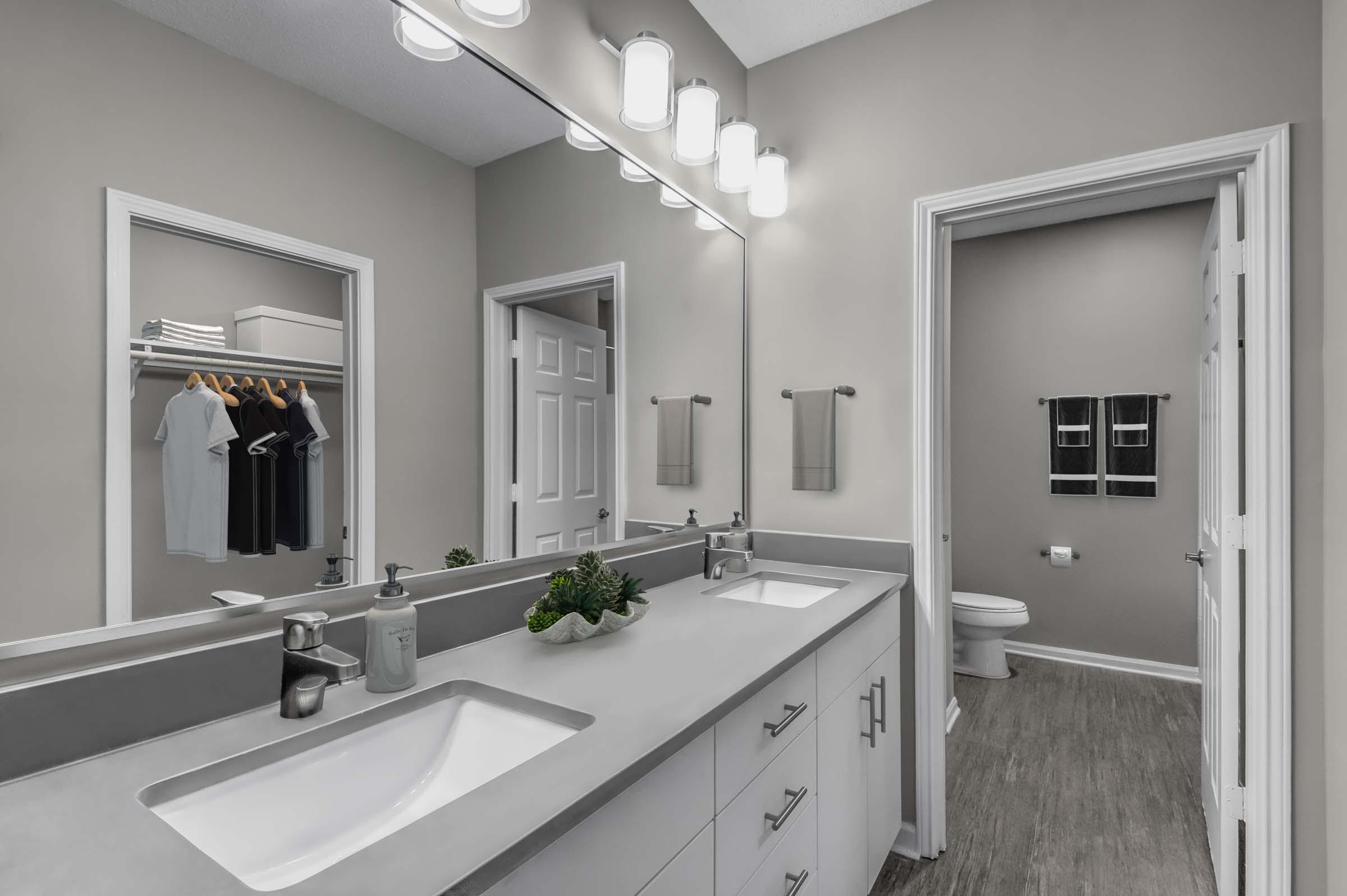 Bathroom with double vanity sink wood look flooring and walk in closet Camden Deerfield Apartments Alpharetta (770)872-6592