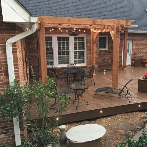 Custom outdoor living space near Badin Lake, North Carolina featuring a covered patio, brick exterior, and stained wood ceiling. This outdoor construction project highlights expert craftsmanship and residential remodeling by a professional general contractor.