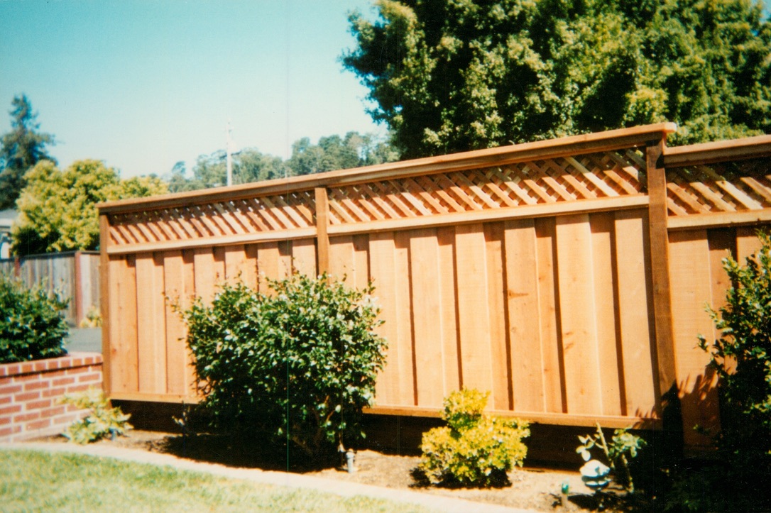 Decorative wood fence with trim detailing designed to enhance curb appeal and define the backyard space.