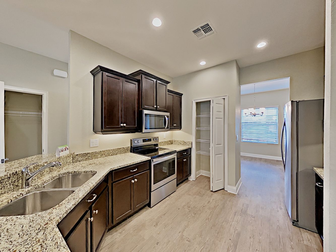 Stunning kitchen with stainless steel appliances, recessed lighting, and granite countertops at Invitation Homes Tampa.