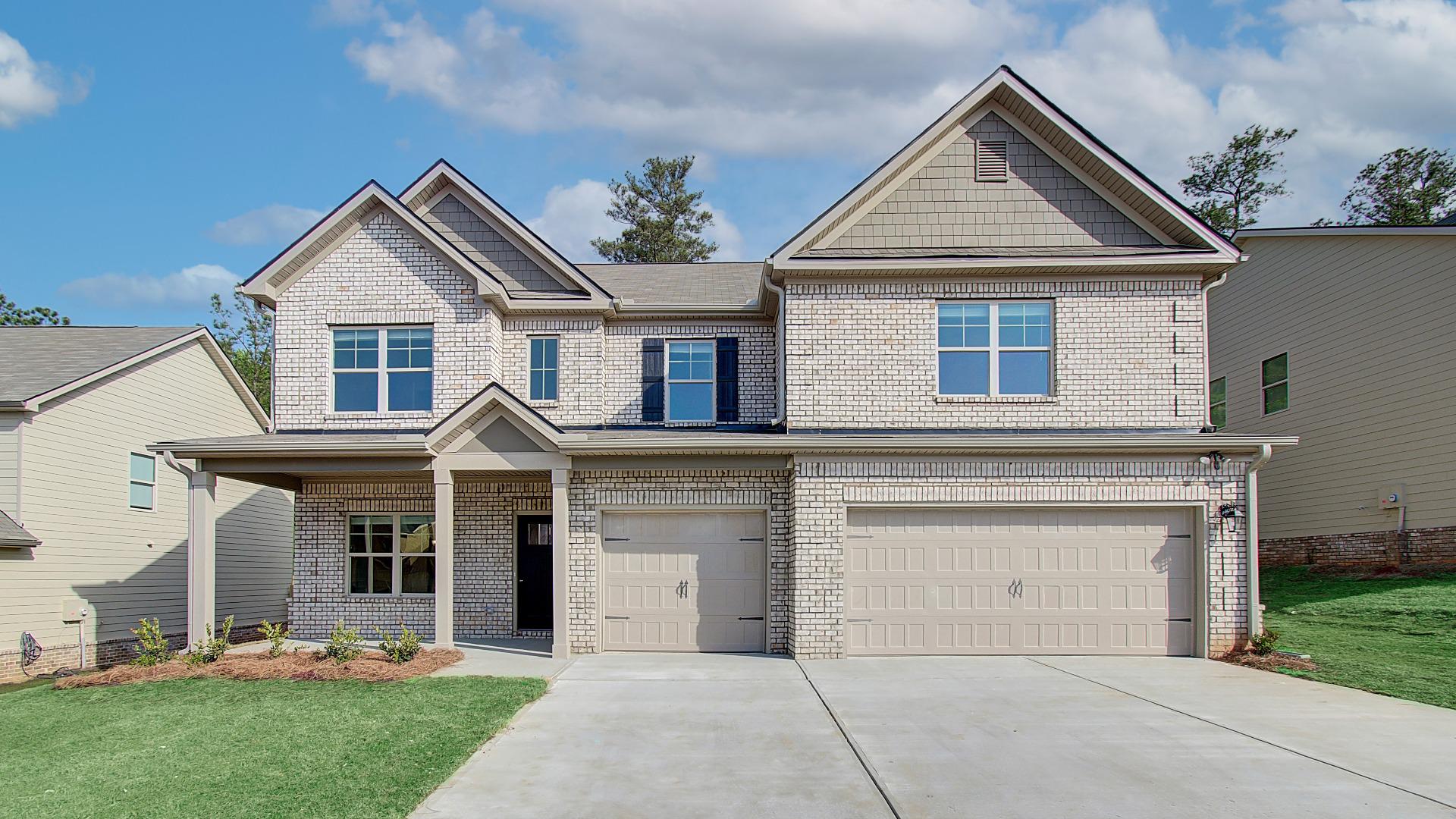 Tan brick two story home with 3 car garage in the DRB Homes Ridgewater community