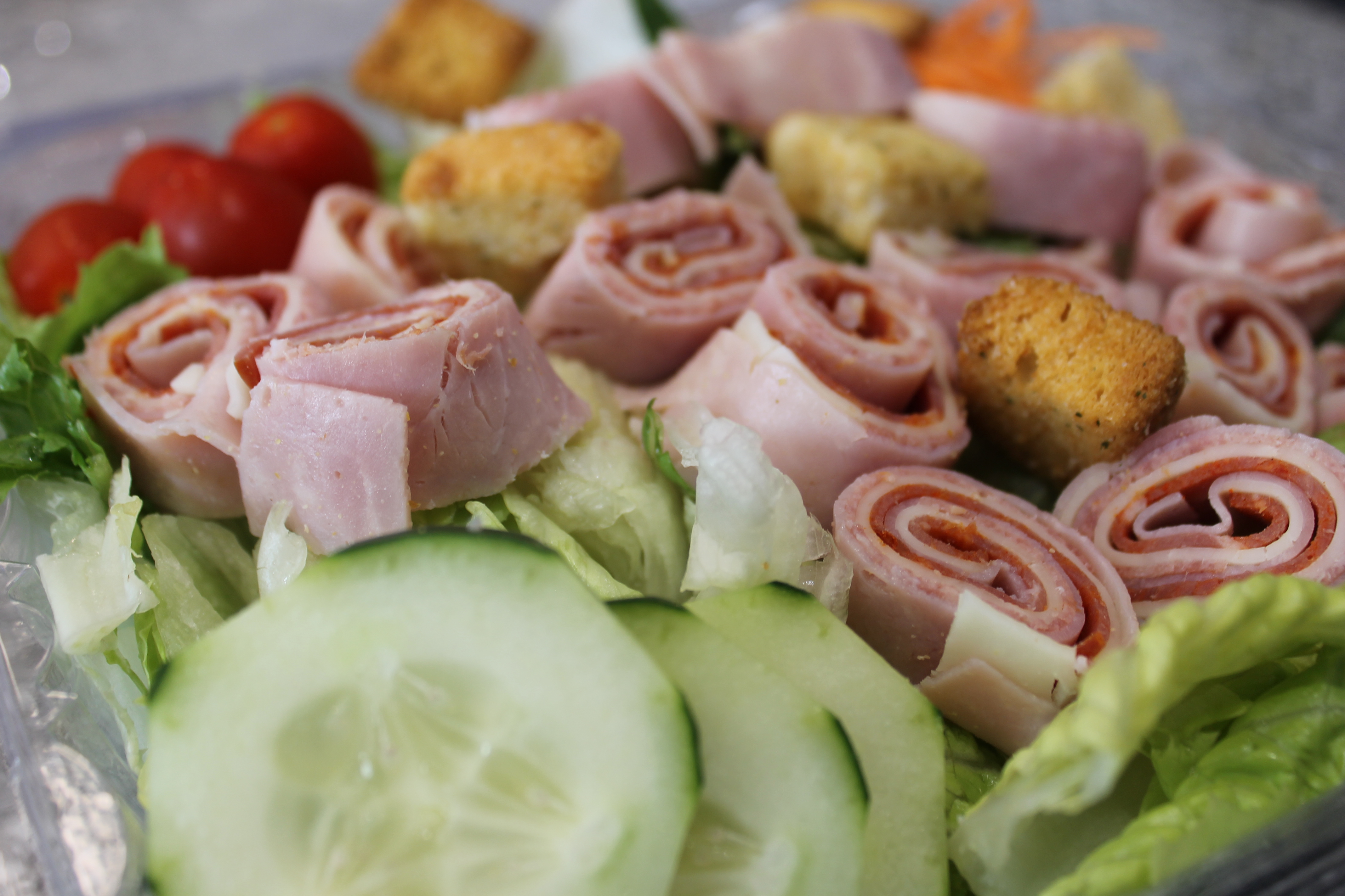Antipasto Salad - Salad mix with shredded carrots, Cherry tomatoes, cucumbers, crouton and chunked provolone cheese topped with Deli ham, Capicola and Genoa salami.  Your choice of dressing