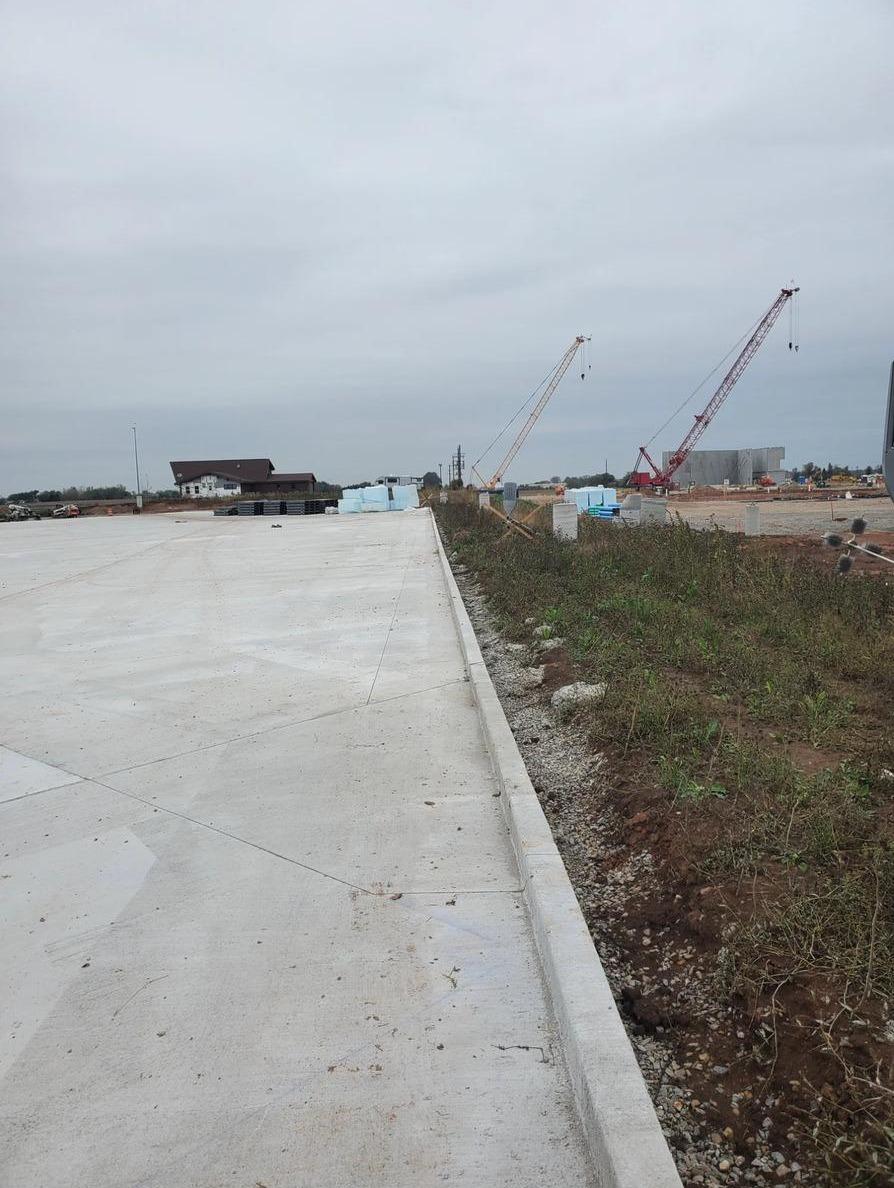 Tilt-up concrete panel construction with cranes erecting wall panels at commercial job site
