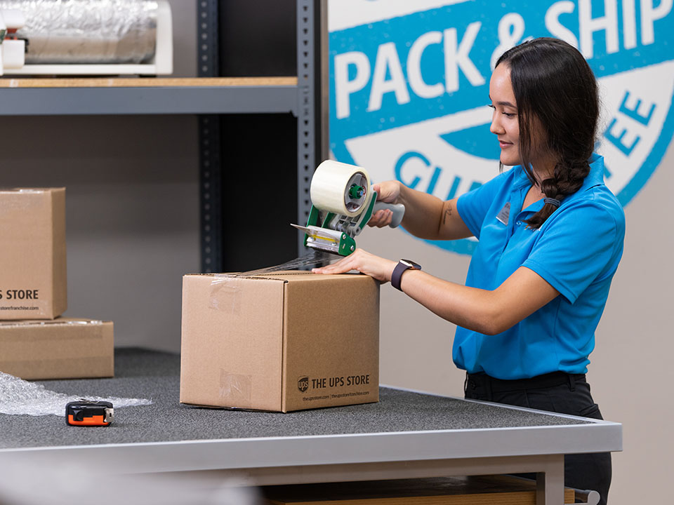 An associate packs a box for shipment from The UPS Store