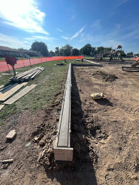 Here's a playground we worked on last year. You can see that we constructed a concrete curb to keep cars from driving into the playground. It sits beside a busy school road. It's all about keeping the kids safe. Do you know of a school or church looking to install a playground? Call us today, we love these projects.