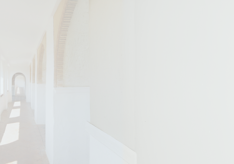 An open-air corridor with warm light shining through.