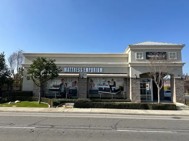 Street view of Mattress Emporium mattress store storefront and sign