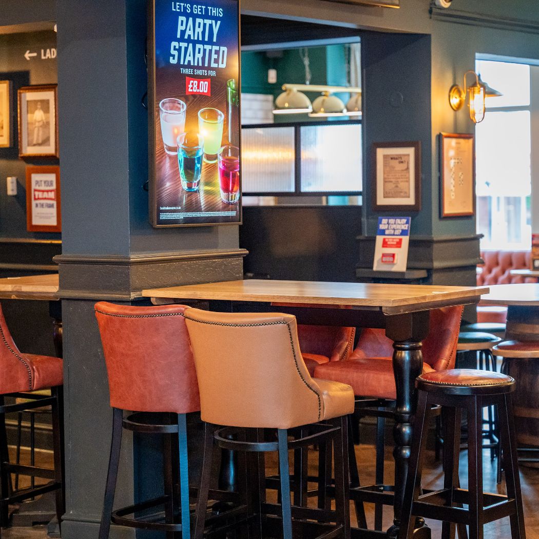 Relaxed seating area with high tables and stools, perfect for casual drinks and meeting friends.