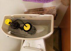 The inside of a toilet tank showing water, a float mechanism, and internal components used to control flushing.