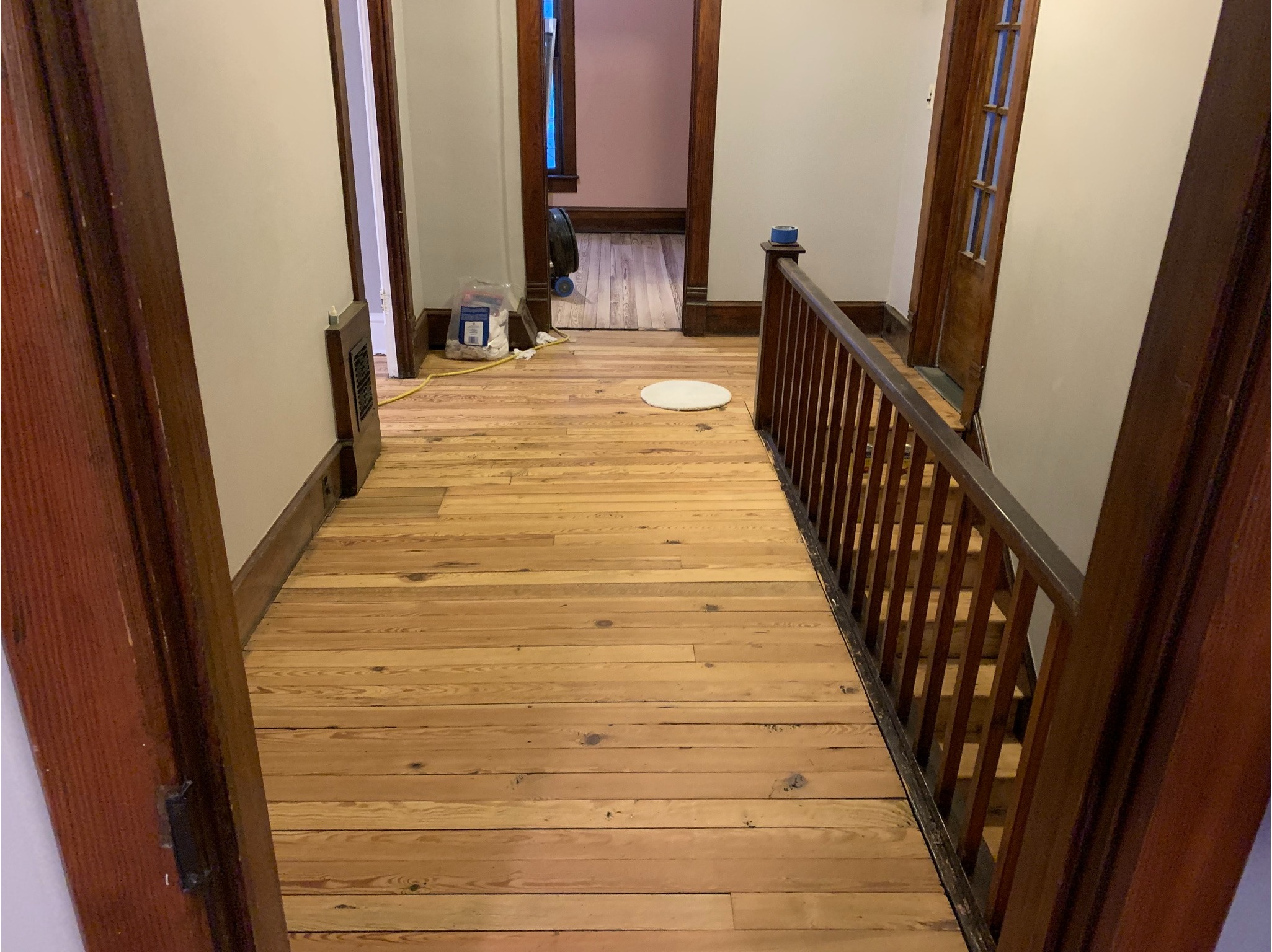 Sanded hardwood hallway floors mid-refinishing project at a residential home in Indiana - Winona FloorCraft hardwood floor restoration service.