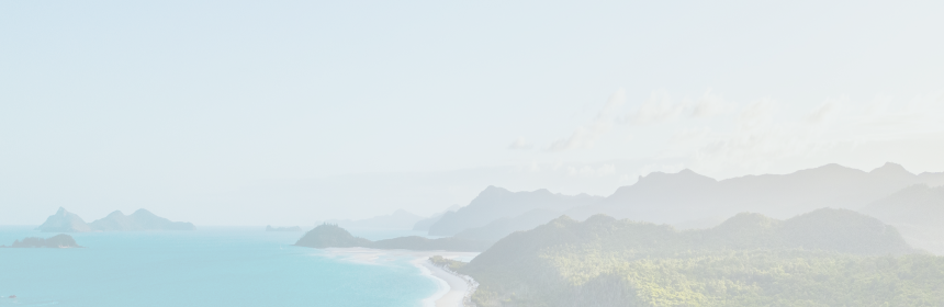 An aerial view of an island with white sand beaches and turquoise waters.