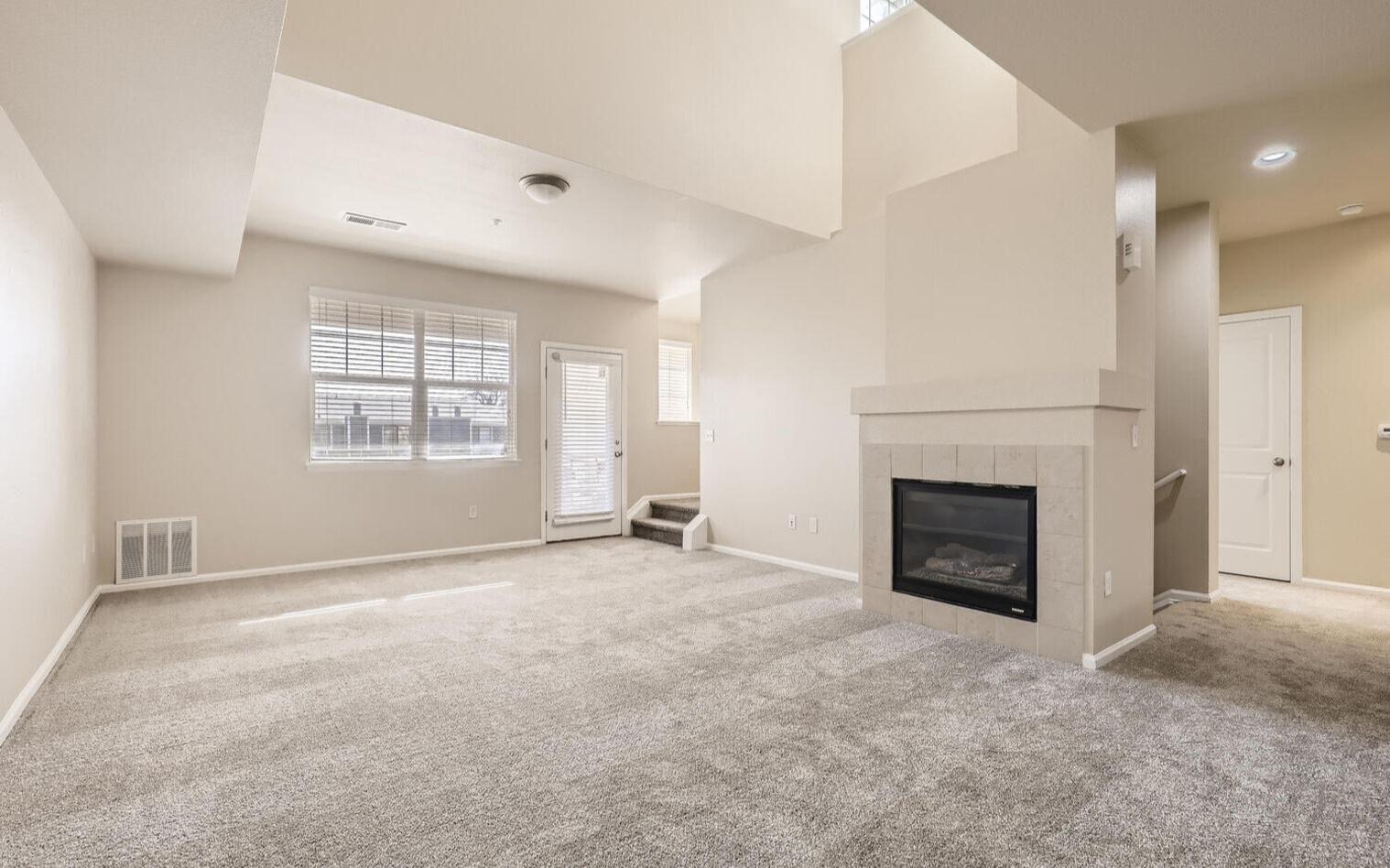 Spacious living room with tall ceilings and a fireplace.