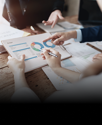 Close-up shot of a client and advisors reviewing documents on a clipboard.
