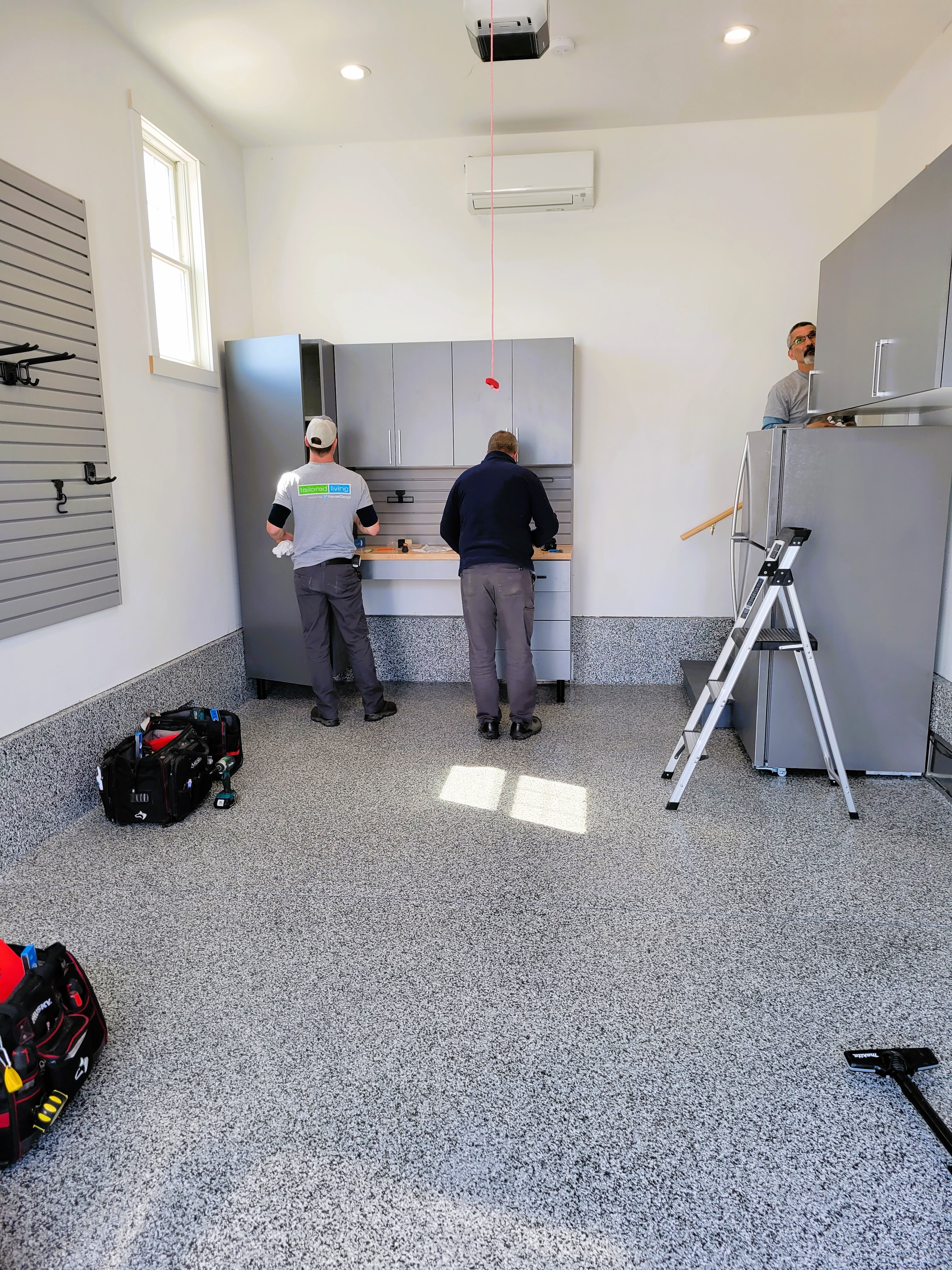 We can turn even an ordinary, small garage into an organization dream come true! In addition to the durable and beautiful Epoxy floor, we installed a sturdy and spacious workbench, garage cabinets and handy slat wall. This little garage now boasts a place for everything and everything in it's place