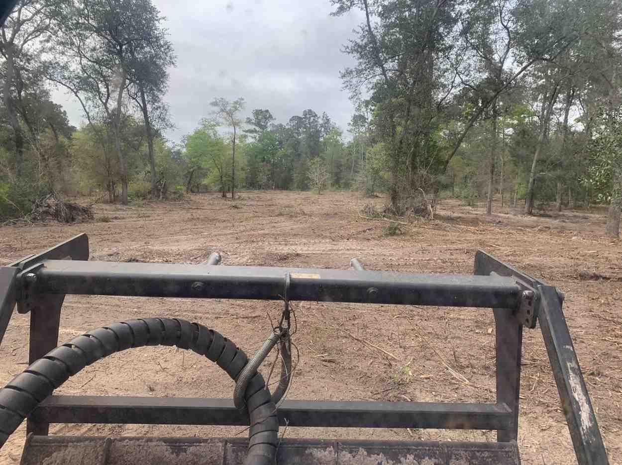 View from land clearing equipment overlooking a newly opened property area where brush, debris, and unwanted vegetation have been removed to improve usability and support future development.