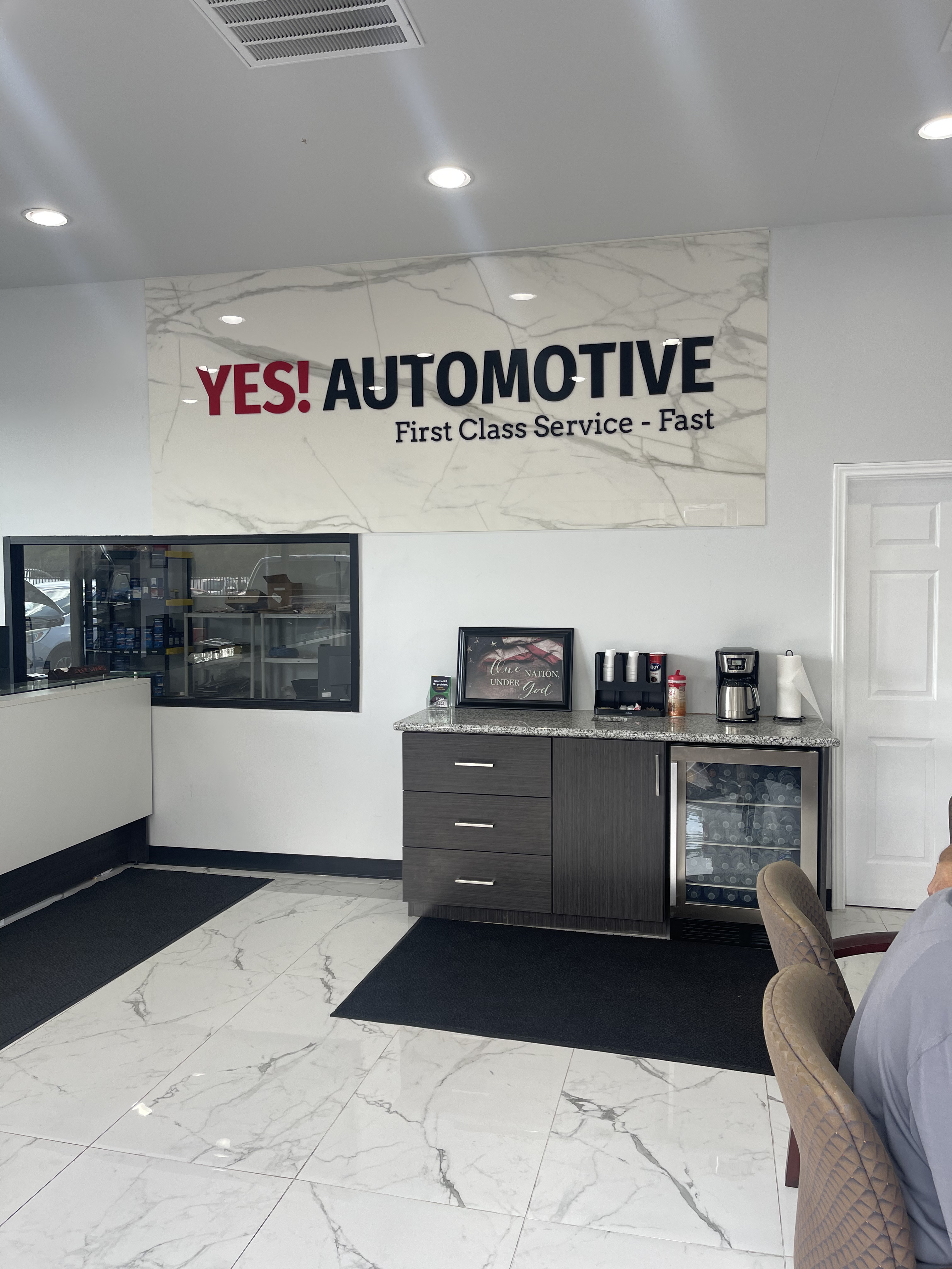 Customer refreshment station at Yes! Automotive in Porter, TX, featuring complimentary coffee and beverages in our clean, comfortable waiting lounge.