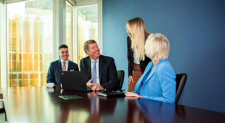 Chris Newall and team working at a boardroom table.