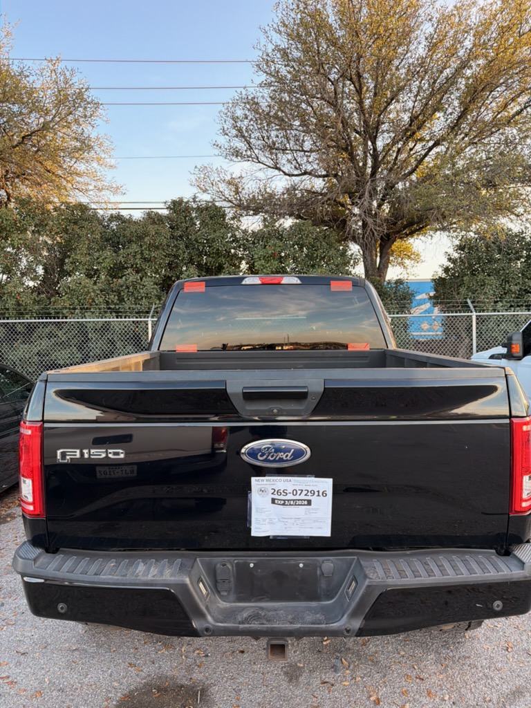 Rear view of a black Ford F-150 showing the rear window installed and secured. The finished result demonstrates rear auto glass replacement for pickup trucks.