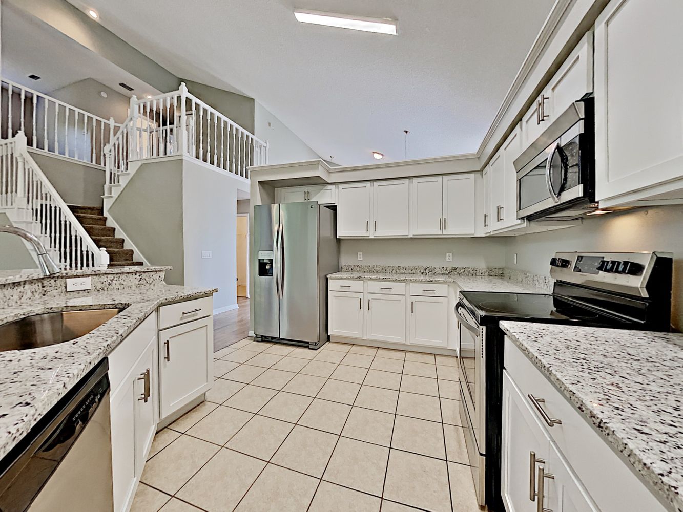 Huge modern kitchen with stainless steel appliances at Invitation Homes Orlando.