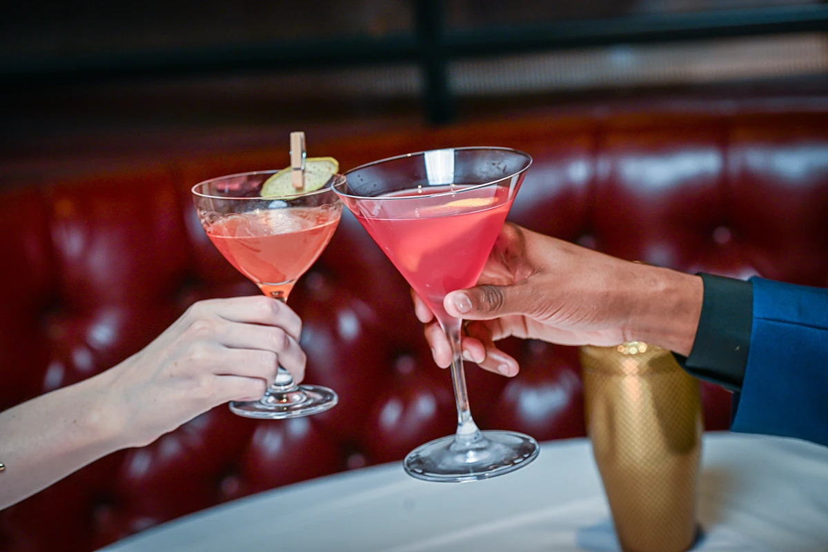 2 people enjoying a cocktail toast