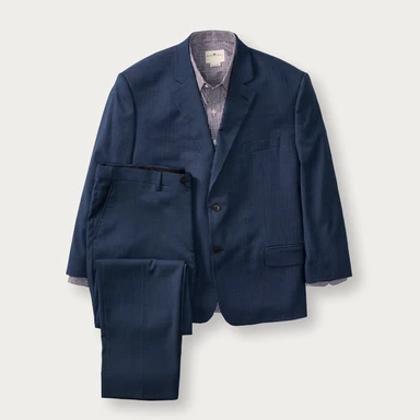 Dark blue suit jacket and suit pants, with a gray button up collared dress shirt.