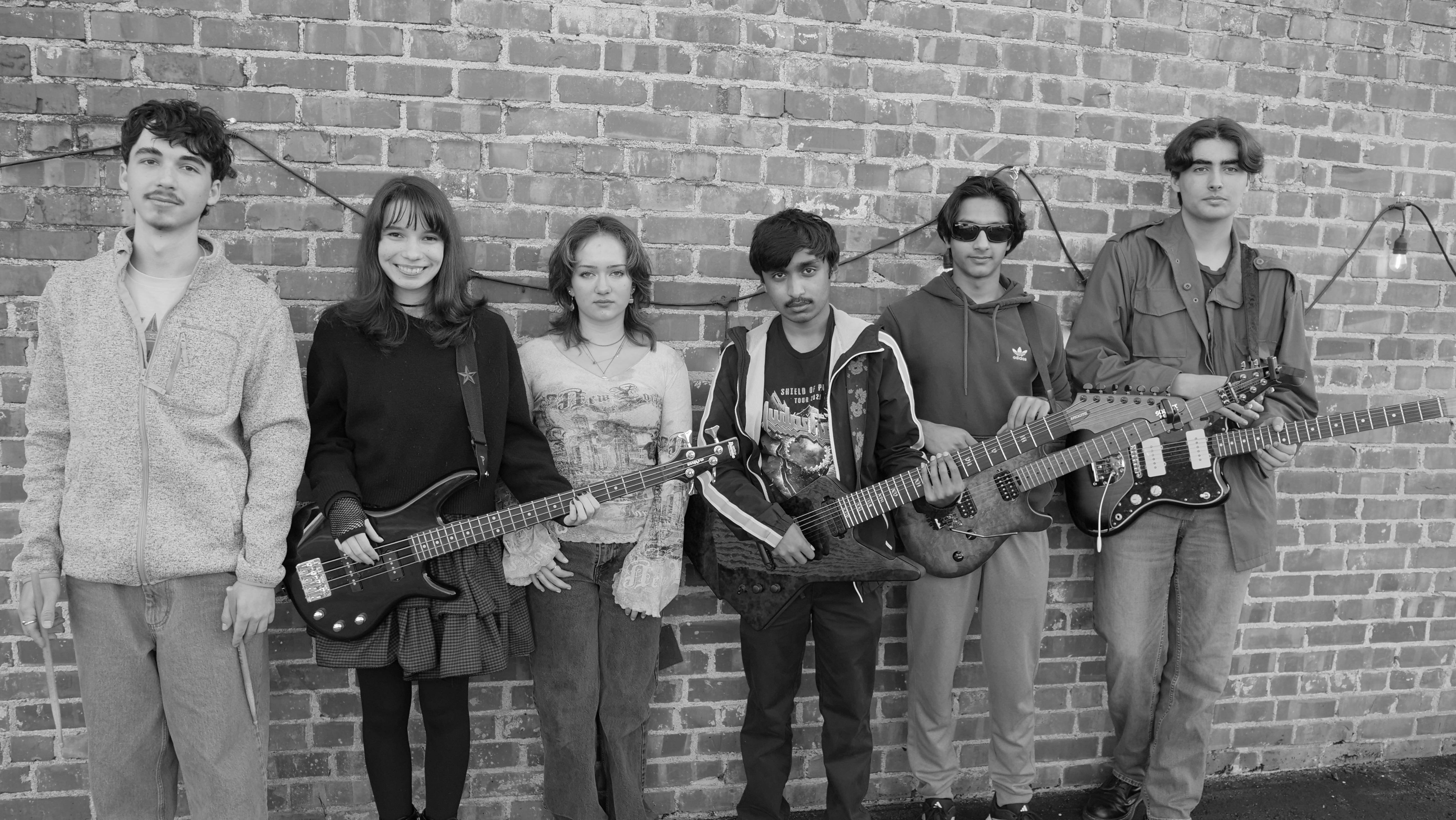 Black-and-white group photo of student musicians performing together during a live band showcase.