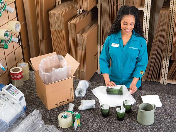 Un asociado embala cristalería frágil para su envío desde The UPS Store.