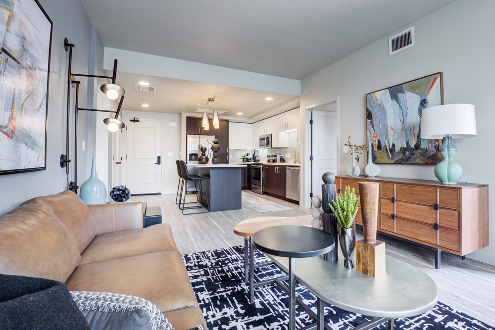 Vinyl-floored living room with couch, coffee table, and view to kitchen.