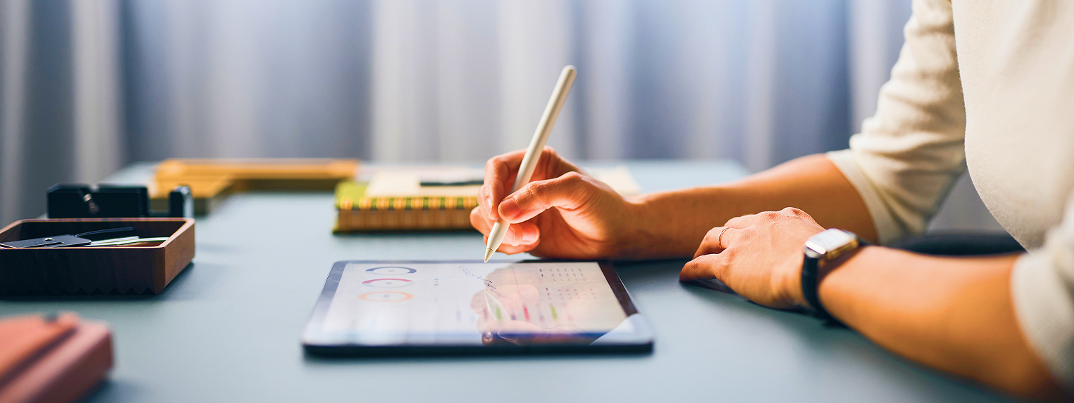 Close up of an investment advisor reviewing files on their iPad.