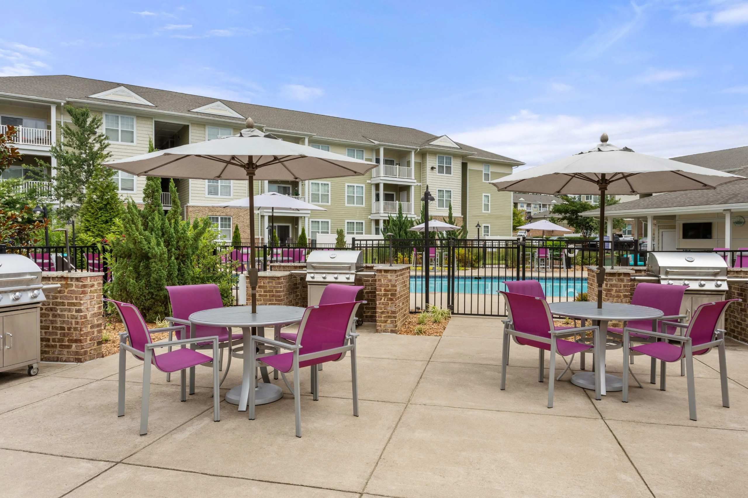 Outdoor grilling area with dining tables and umbrellas