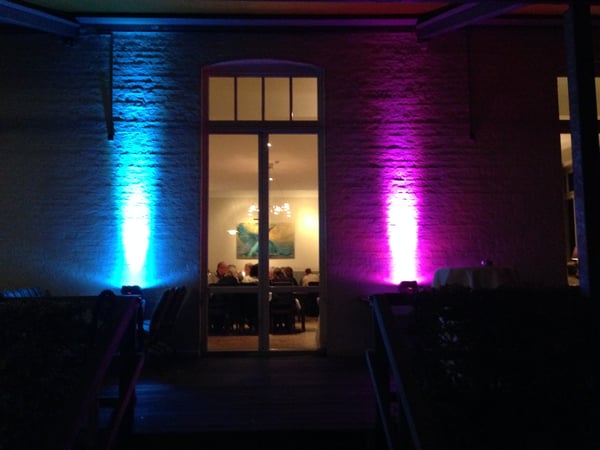 GPM Entertainment - DJ Münster Außenbeleuchtung in Pink und Blau an Gebäudewand. DJ Münster sorgt mit Event-Lichttechnik für romantisches Ambiente bei Hochzeiten und Feiern.
