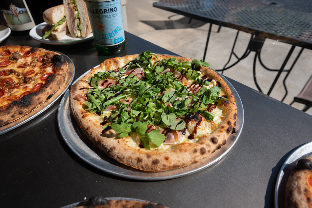 Authentic wood fired, artisan pizza with fresh arugula, prosciutto, goat cheese, ricotta, truffle oil and balsamic glaze. Ingredients shipped in from Italy for a truly authentic experience.
