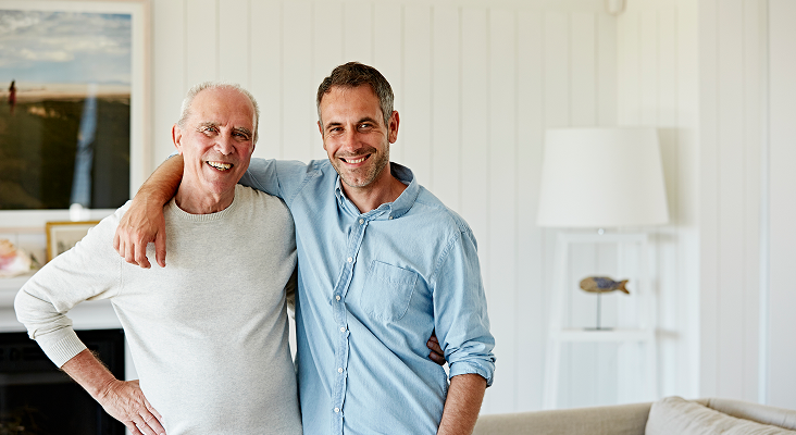 A father and son smiling at the camera.