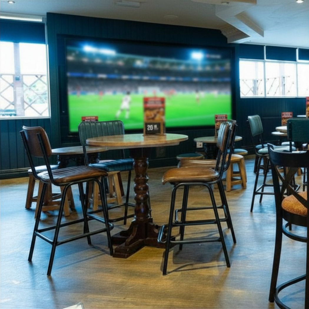 Spacious seating area with a large screen for live sports, offering a lively setting for match days.