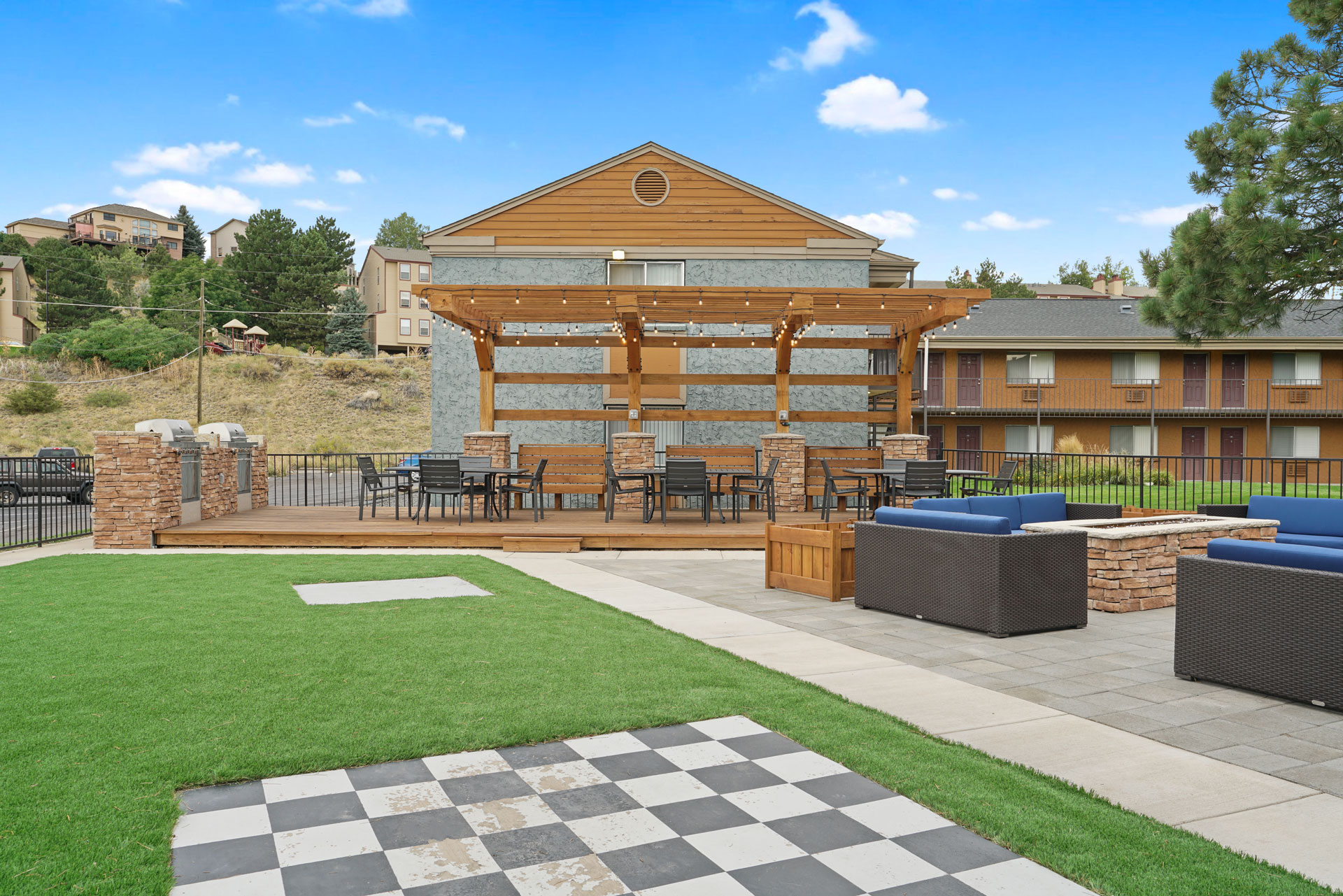 A large wooden building with a checkered pattern on the ground in front of it.