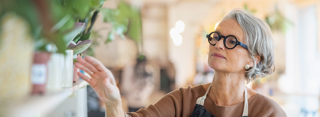 A woman in an apron managing a coffee shop.