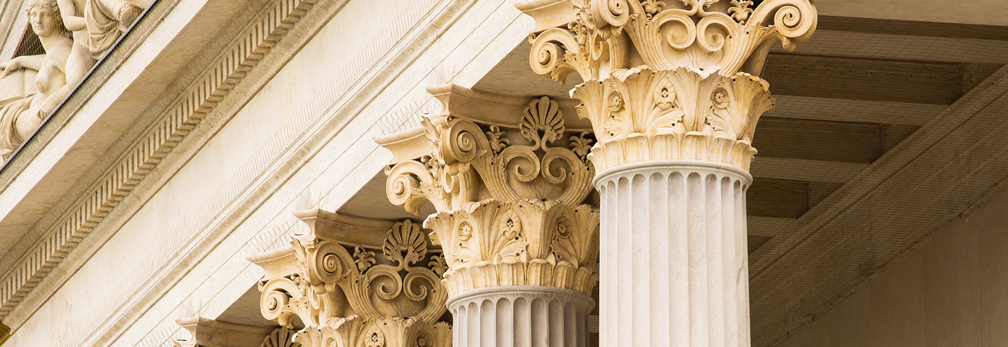 Close-up of a Greco-Roman building featuring columns with decorative capitals.