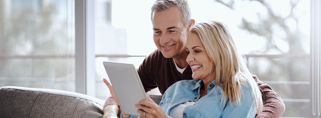 A couple accessing their account information from a tablet.