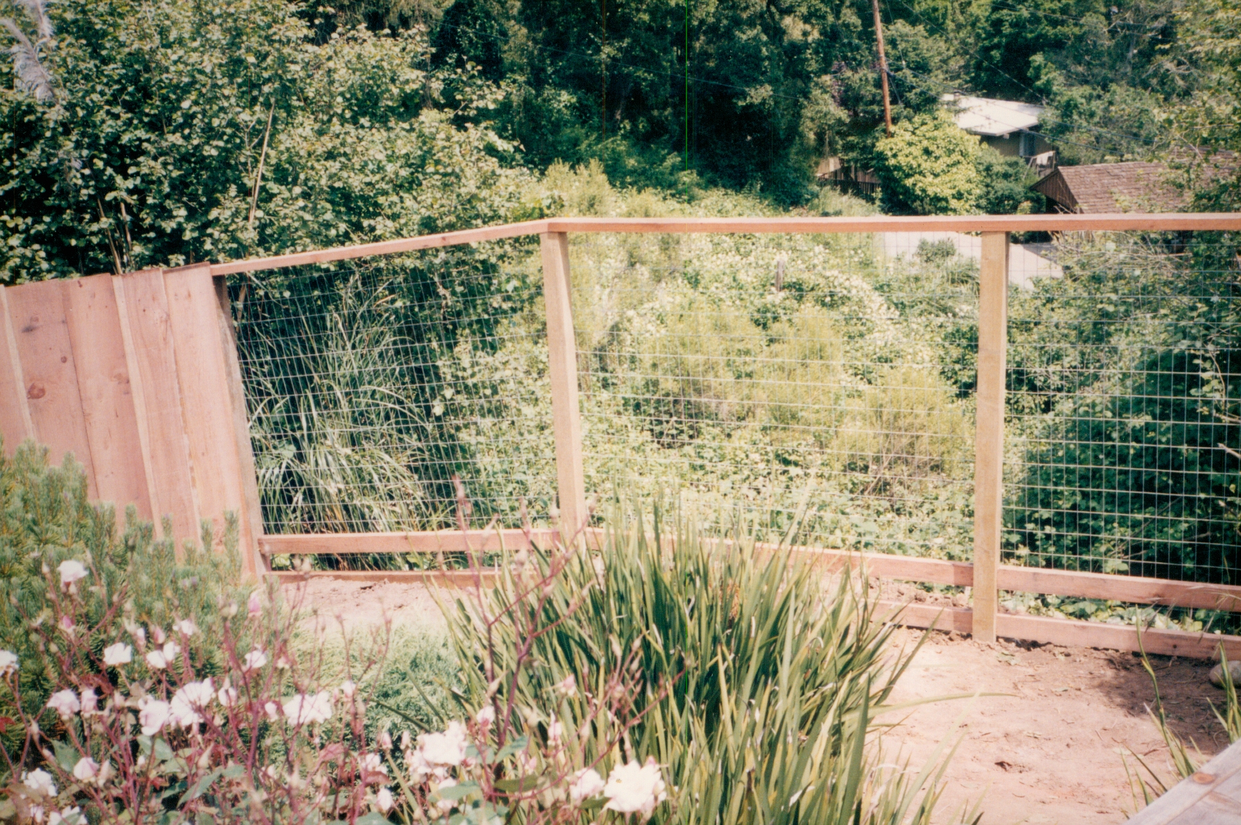Decorative garden fence with wire mesh panels designed to protect landscaping while maintaining an open view.