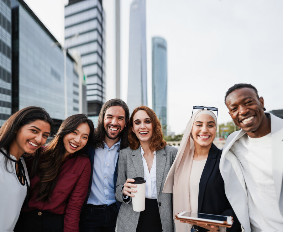 A diverse group of six business professionals, three women and three men, are posing for a photo out 