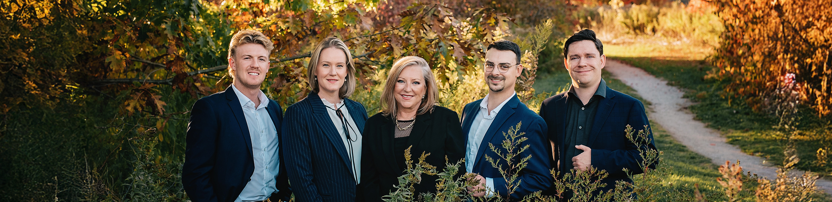 The Brenda Miller Family Wealth team posed outside among the multi-coloured autumn trees.