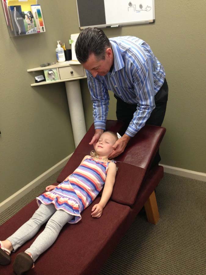 Dr. Pontious performing adjustment on child