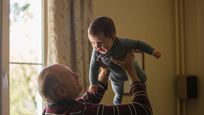A grandfather holding his grandchild.