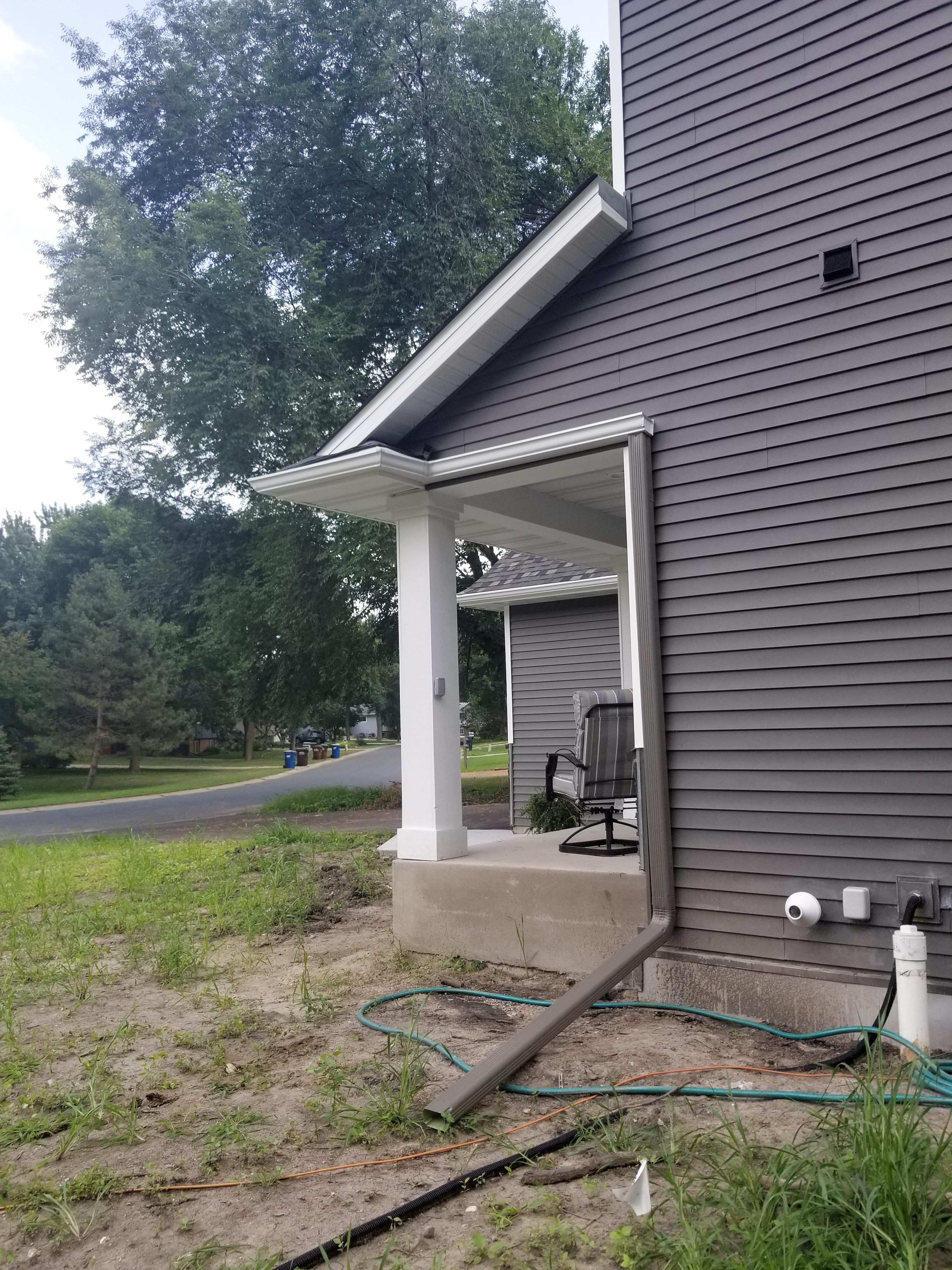 Custom color downspout and white seamless gutters installed by Ultimate Gutter Solutions.
