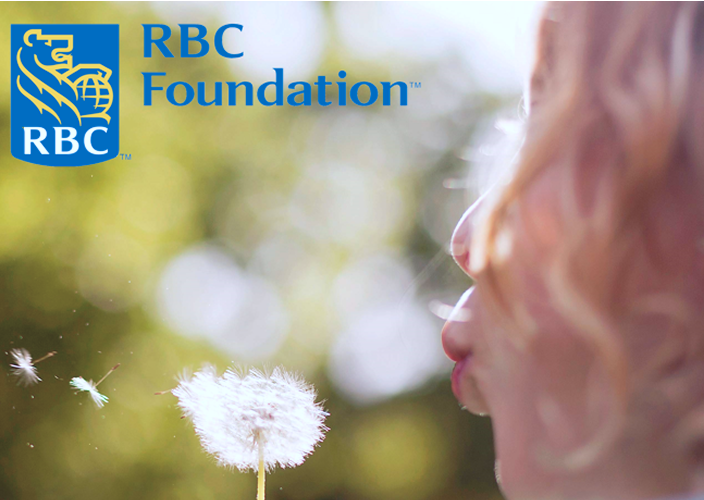 A girl blowing on a dandelion.