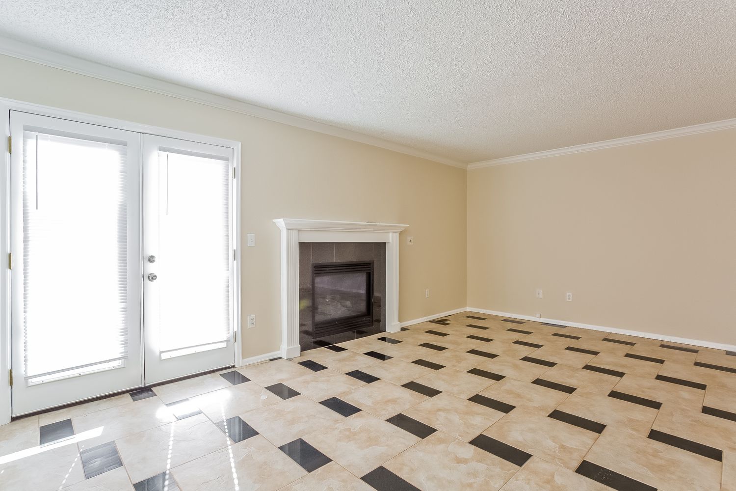 Living room with backyard access, fireplace and unique tile flooring at Invitation Homes Denver.